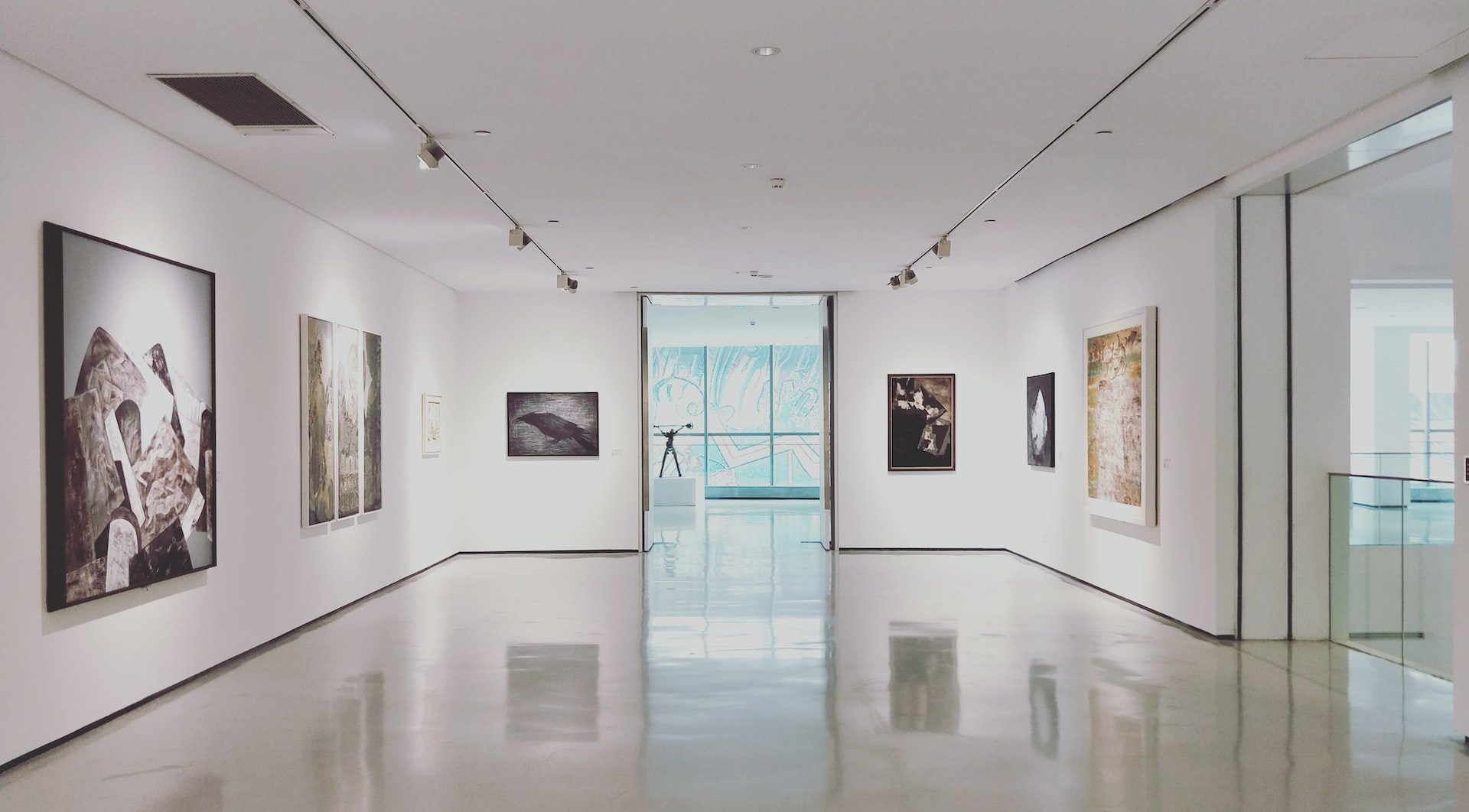 Art gallery with white walls and seven wall-mounted pieces of art